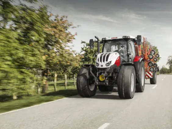 Steyr Profi CVT 6145 på landevei med samlerive på slep