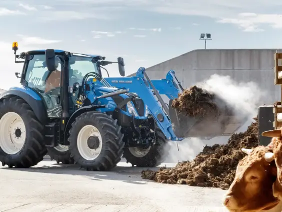 New Holland T5 Dynamic Command og Auto Command i arbeid med frontlaster på gården.