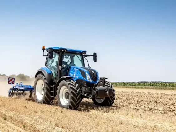 Blå traktor av typen T5 Dynamic Command og Auto Command i arbeid på åkeren.