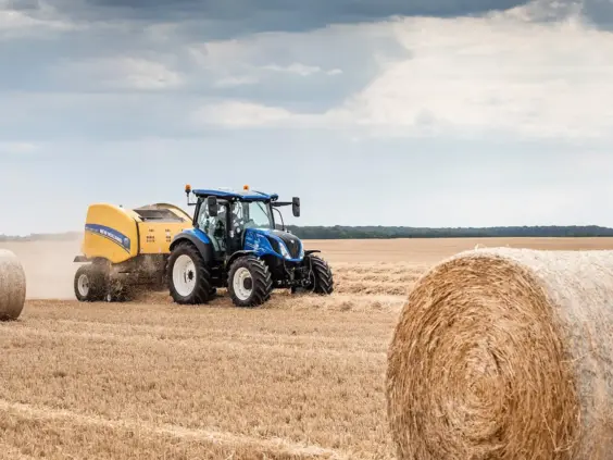 Blå New Holland traktor T5 Dynamic Command og Auto Command i arbeid på en åker.