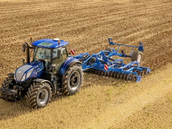 Blå New Holland T7 LWB med PLM Intelligence i arbeid på en åker.