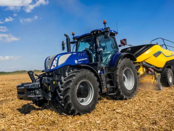 Blå New Holland T7 LWB med PLM Intelligence traktor i arbeid på en åker.