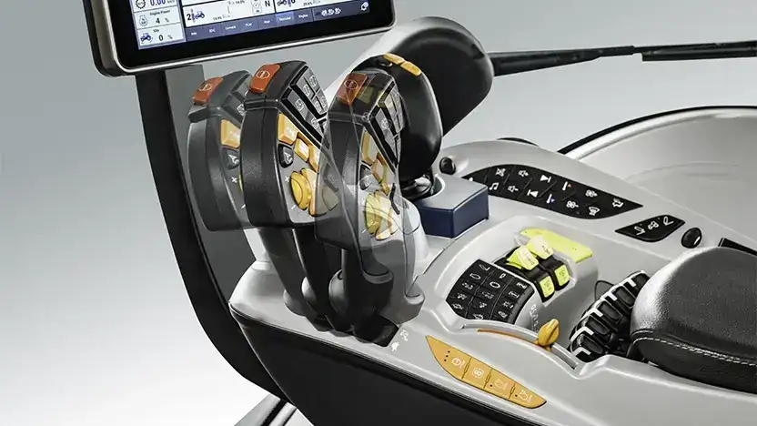 Det justerbare armlenet med kontrollspak og skjerm i en New Holland T8 Genesis traktor.