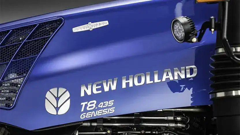 Nærbilde av det blå panseret på en New Holland T8 Genesis traktor.