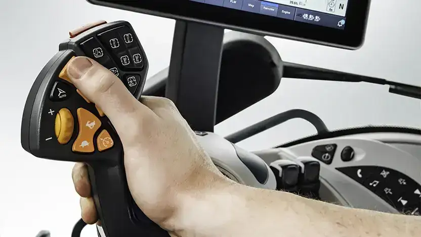 En hånd som betjener den ergonomiske kontrollspaken i en New Holland T8 Genesis traktor.