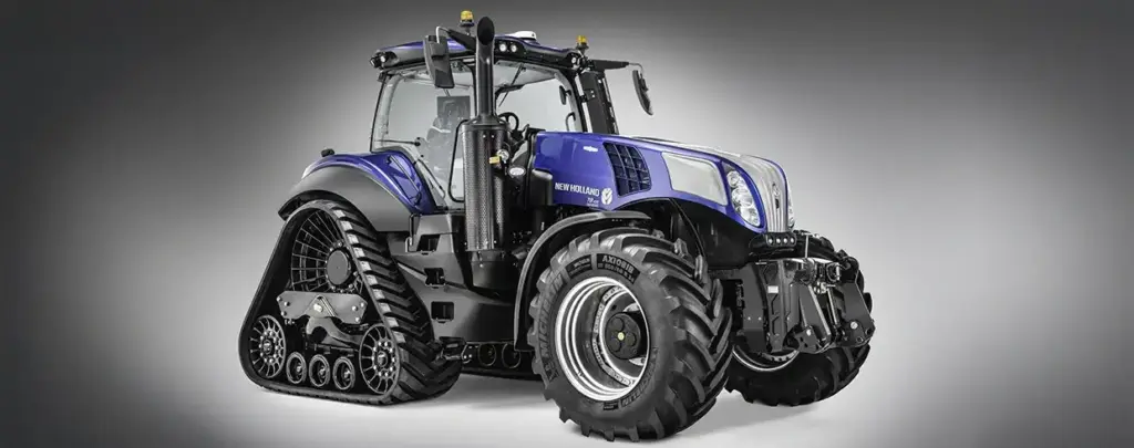En blå New Holland T8 Genesis traktor med belter bak og store dekk foran.