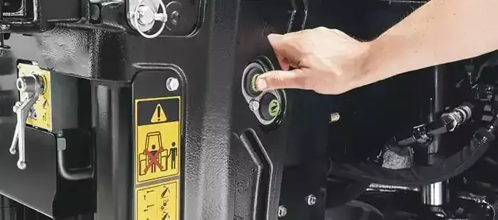 En hånd som trykker på en knapp på en New Holland T8 Genesis traktor.