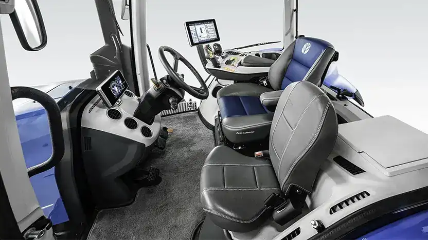 Det moderne og romslige førerhuset på en New Holland T8 Genesis traktor med skinnseter.