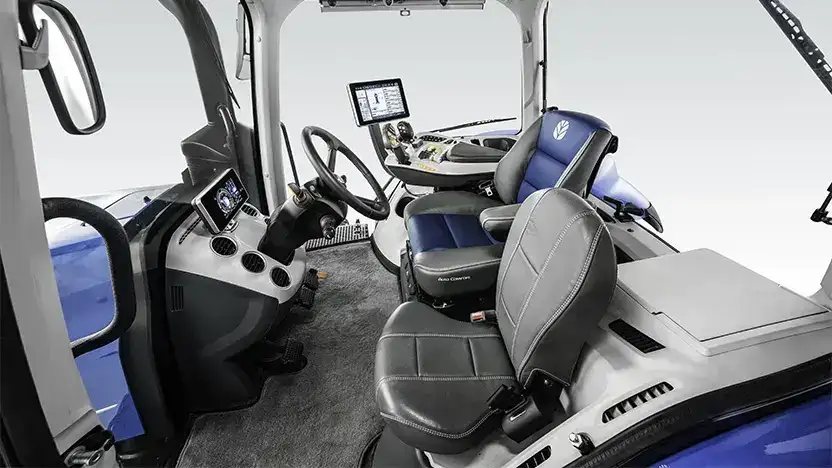 Det romslige og moderne interiøret i førerhuset på en New Holland T8 Genesis traktor.