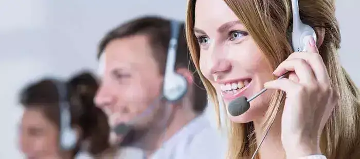 Kundeservicemedarbeider med headset som tilbyr support for New Holland T8 Genesis.