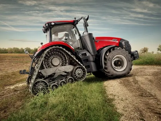 Rød Case IH traktor fra Magnum-serien med belter på et jorde under skyet himmel.