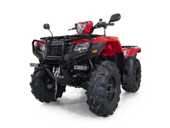 En rød Honda TRX520FA6 ATV med kraftige terrengdekk og frontbøyle mot hvit bakgrunn.