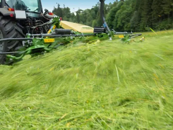En KRONE Vendro spreder i full sving med å spre nyslått gress på jordet.