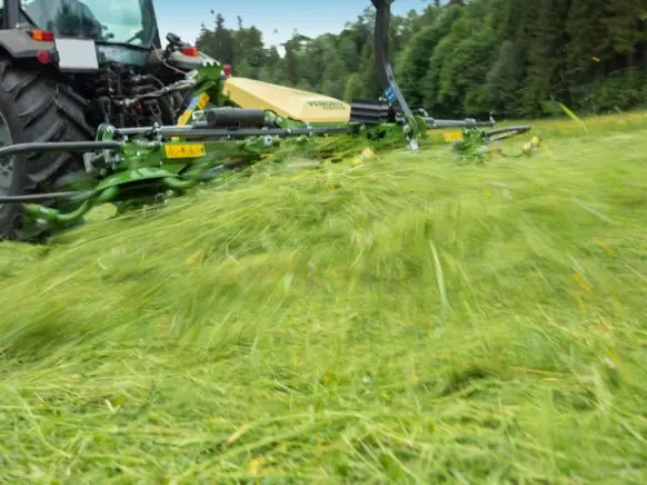 En KRONE Vendro spreder i full sving med å spre nyslått gress på jordet.