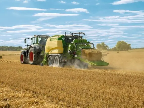 En traktor som trekker en KRONE BigPack 5. gen i en kornåker.