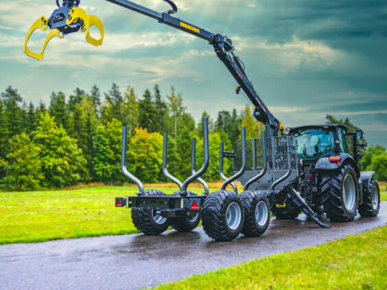 Svart traktor og tømmertilhenger med Palms 5.87z kran på en vei.