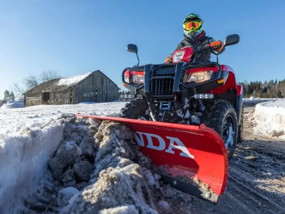 Honda TRX520FA6 brøyter snø med skjær foran
