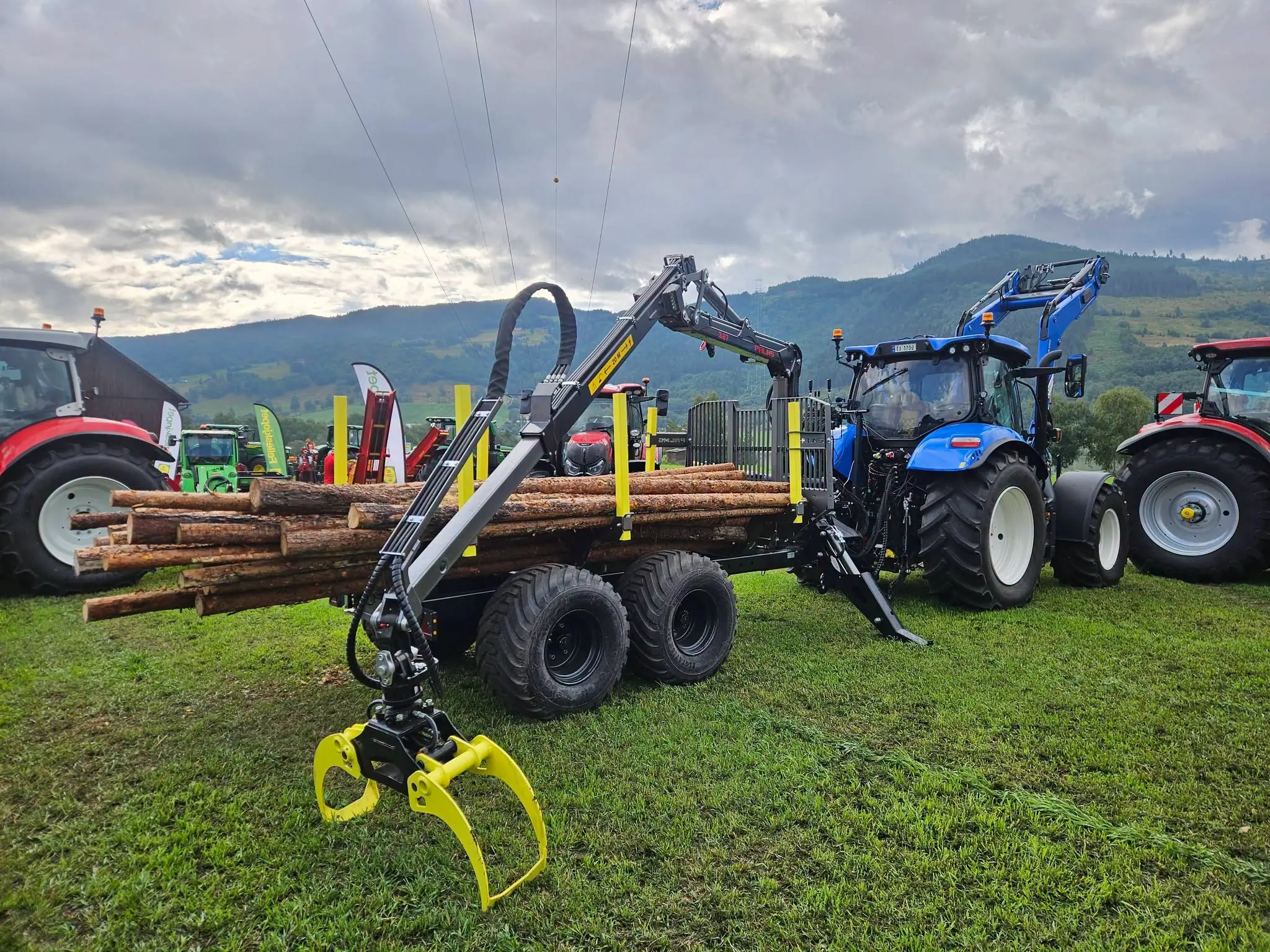 PALMS 8D tømmervogn lastet med tømmer, koblet til New Holland-traktor med PALMS 3.67 skogskran.