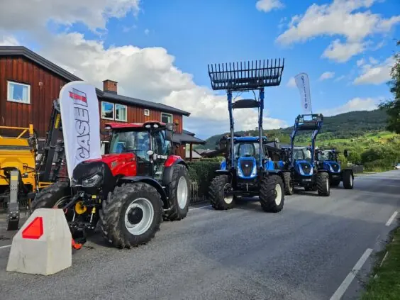 Røde og blå traktorer stilt opp i en gate under Traktorrock Vågåmo.