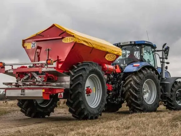 Traktor med enkeltakslet Bredal kalkspreder i arbeid