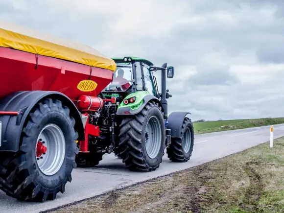 Enkeltakslet Bredal kalkspreder på vei bak traktor