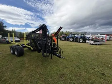 PALMS tømmervogn med skogskran på standen til Fron Traktor Service, med Case IH- og New Holland-traktorer i bakgrunnen på Bygdedagene på Dokka.
