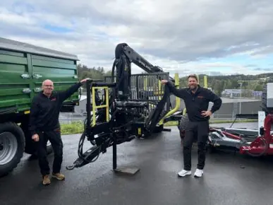 To medarbeidere fra Fron Traktor Service Gjøvik ved en PALMS 8SX tømmervogn med PALMS 3.67 skogskran.