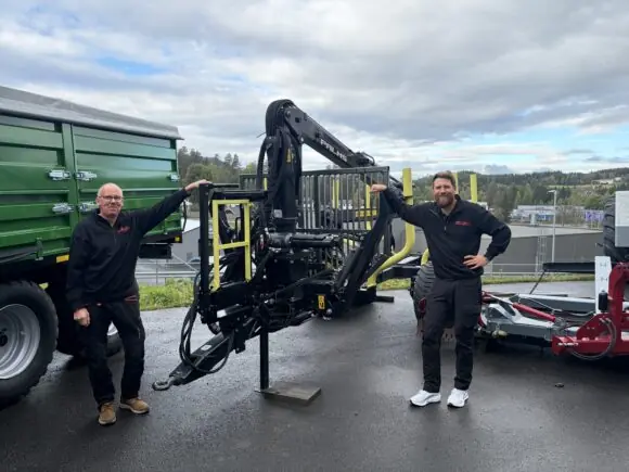 To medarbeidere fra Fron Traktor Service Gjøvik ved en PALMS 8SX tømmervogn med PALMS 3.67 skogskran.