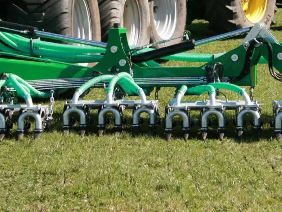 SAMSON TD 12 nedfeller med dobbeltskjær legger blautgjødsel i eng bak traktor