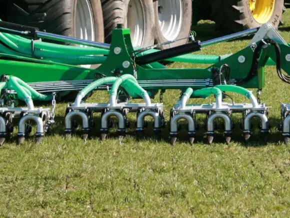 SAMSON TD 12 nedfeller med dobbeltskjær legger blautgjødsel i eng bak traktor