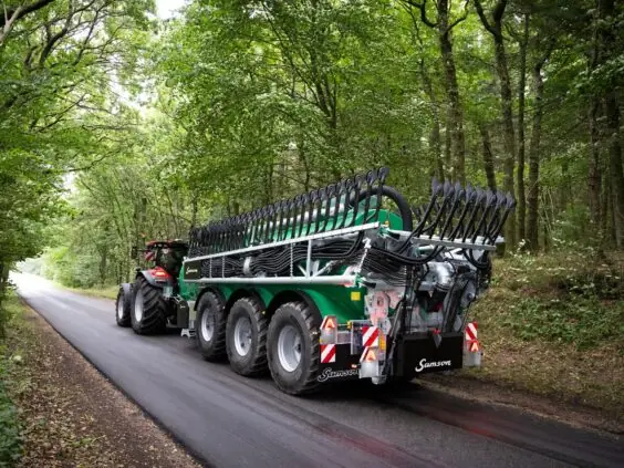 Gjødselvogn med sammenfoldet SAMSON TSB2 i transportstilling på en smal skogsvei.