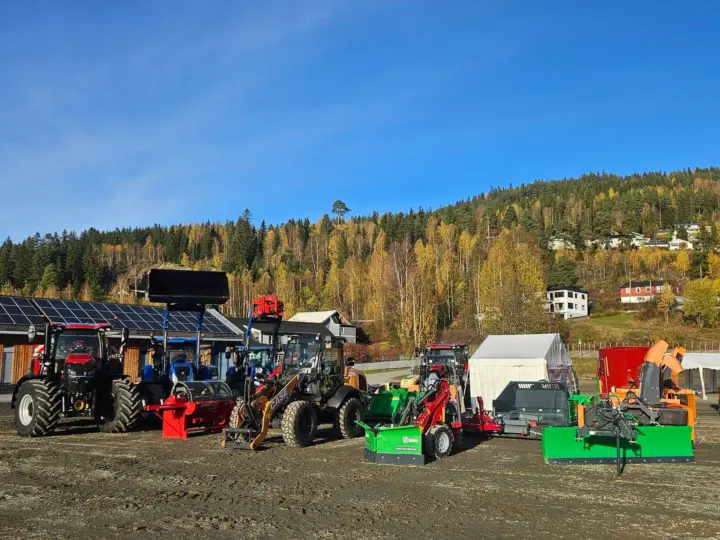 Standen til Fron Traktor Service på Stavsmartn på Tretten, med Case IH- og New Holland-traktorer og redskap stilt opp på grusen.