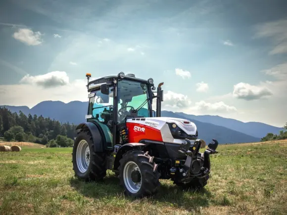 Steyr Spezial F CVT 4120 med frontlift på eng med fjell i bakgrunnen