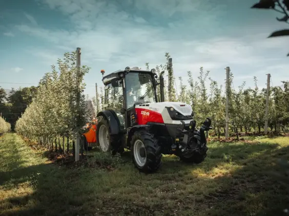Steyr Spezial F CVT med tåkesprøyte mellom radene i en eplehage